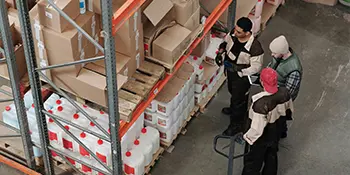 Trois personnes devant un stock de produits chimiques